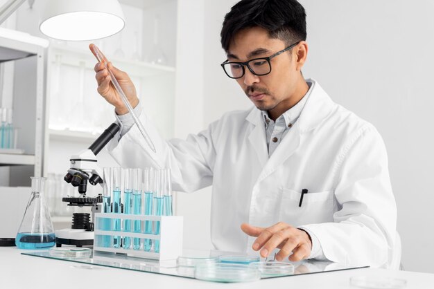 Retrato de hombre en laboratorio trabajando con microscopio