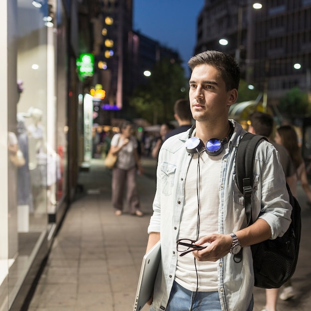 Retrato de un hombre con laptop haciendo compras de ventana