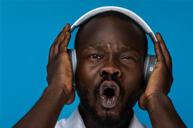 Retrato de hombre loco escuchando música en auriculares