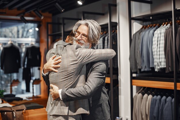 Retrato de un hombre maduro. Asistente ayuda a un cliente. Senior visitando una boutique de moda. Hombre compra un nuevo disfraz exclusivo.