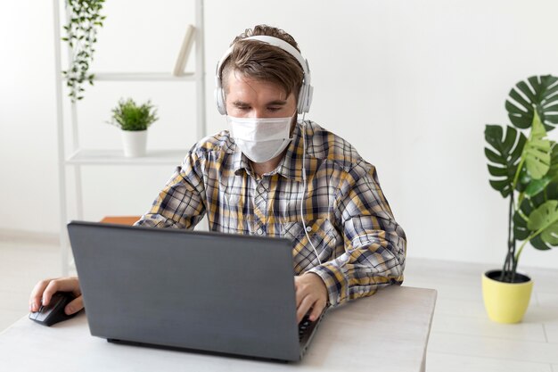 Retrato de hombre con mascarilla trabajando desde casa