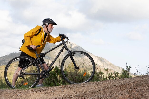 Retrato, hombre mayor, con, bicicleta, en, montaña