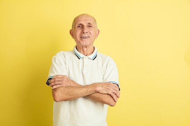 Retrato del hombre mayor caucásico aislado en estudio amarillo