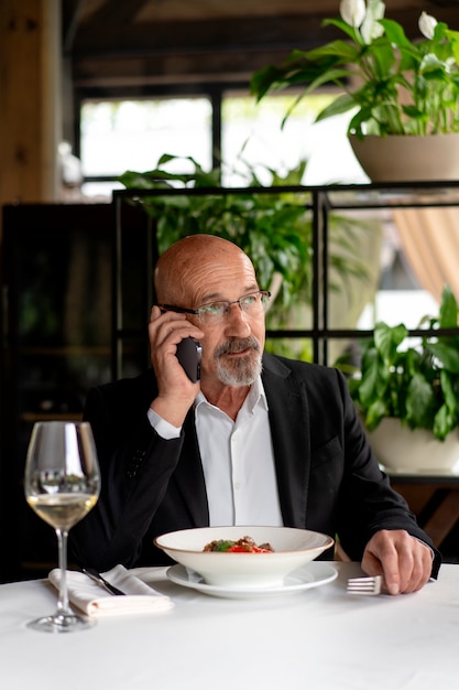 Foto gratuita retrato, de, hombre mayor, en, un, lujoso, restaurante