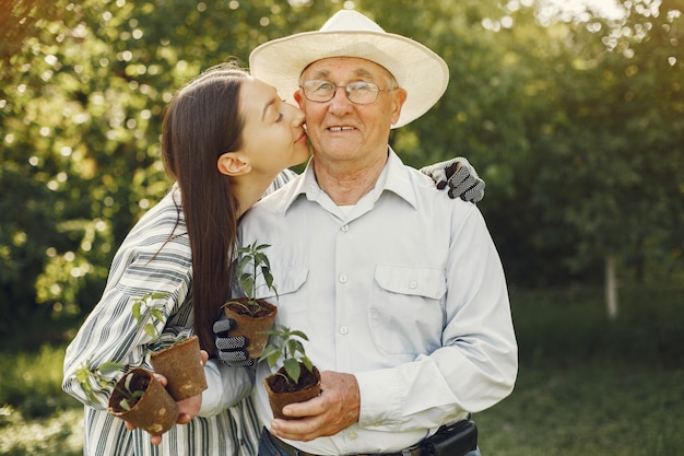 Retrato de hombre mayor con un sombrero de jardinería con granddaugher