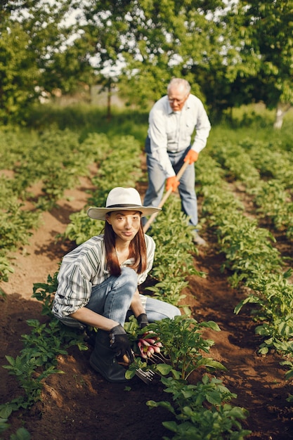 Foto gratuita retrato de hombre mayor con un sombrero de jardinería con granddaugher