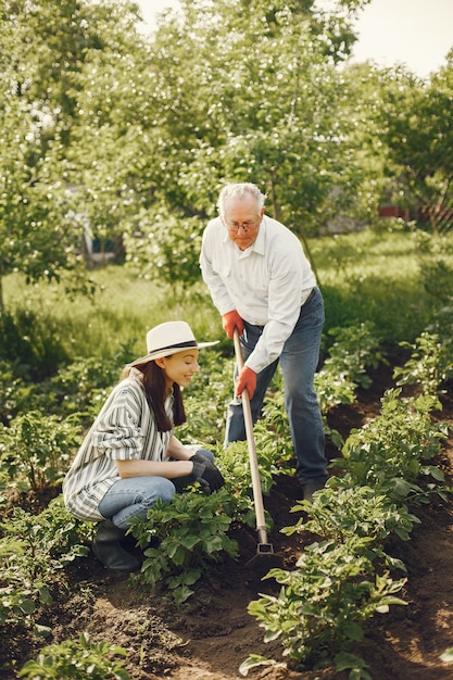 Retrato de hombre mayor con un sombrero de jardinería con granddaugher