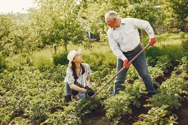 Retrato de hombre mayor con un sombrero de jardinería con granddaugher