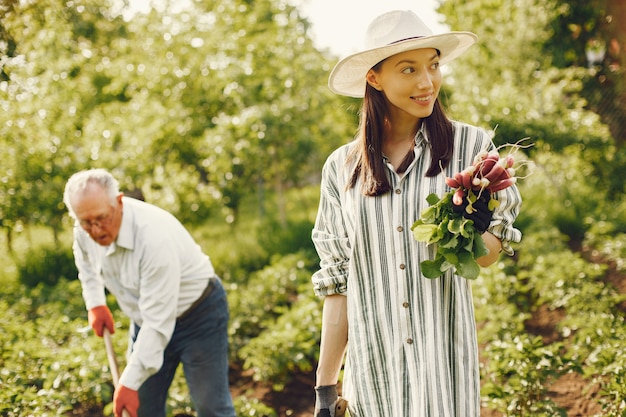 Retrato de hombre mayor con un sombrero de jardinería con granddaugher
