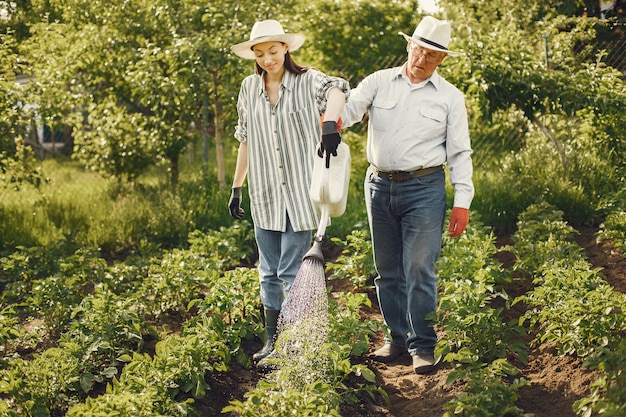 Retrato de hombre mayor con un sombrero de jardinería con granddaugher