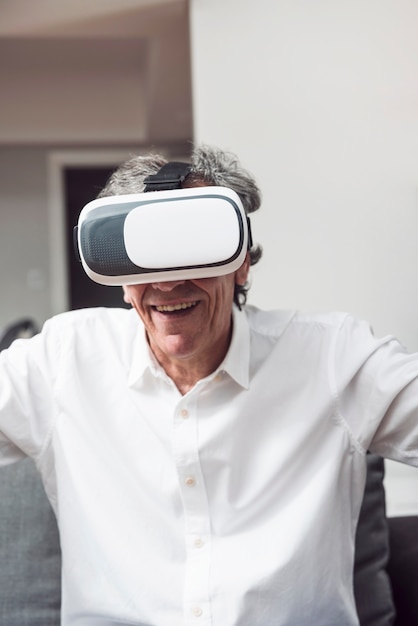 Retrato de hombre mayor sonriente con gafas de realidad virtual