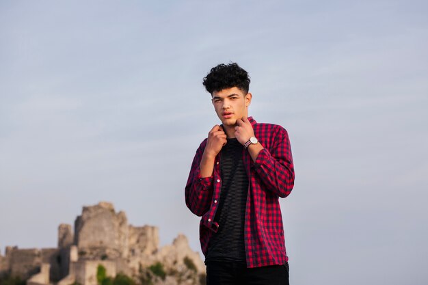 Retrato del hombre de moda que sostiene su cuello de la camisa