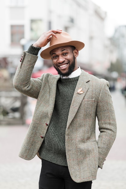 Foto gratuita retrato de hombre de moda sonriendo afuera