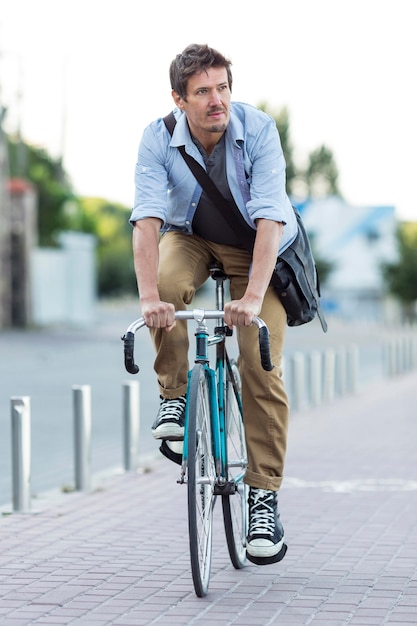 Foto gratuita retrato de hombre montando bicicleta en la ciudad