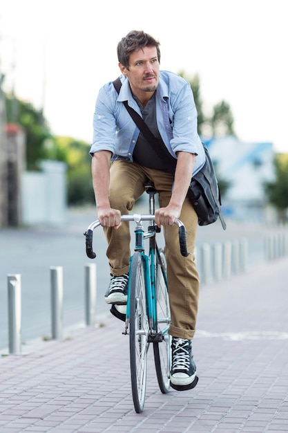 Retrato de hombre montando bicicleta en la ciudad