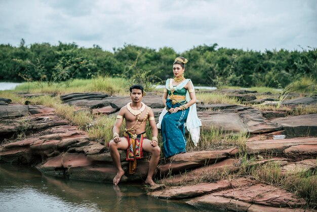 Retrato de hombre y mujer joven con hermoso traje tradicional posan en la naturaleza en Tailandia