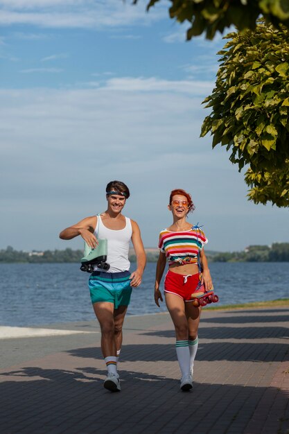 Retrato de hombre y mujer en la playa con patines en la estética de los 80