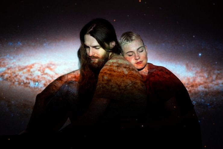 Foto gratuito retrato de hombre y mujer posando con textura de proyección del universo