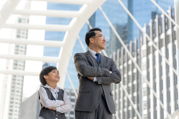 Retrato de hombre de negocios asiático y su hijo en el distrito de negocios