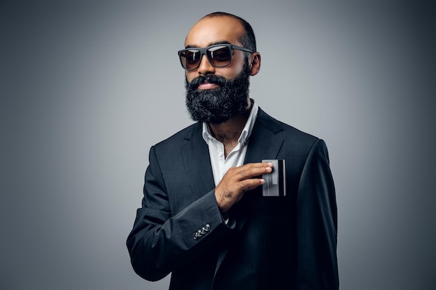 Foto gratuita retrato de un hombre de negocios barbudo vestido con un traje aislado de fondo gris.