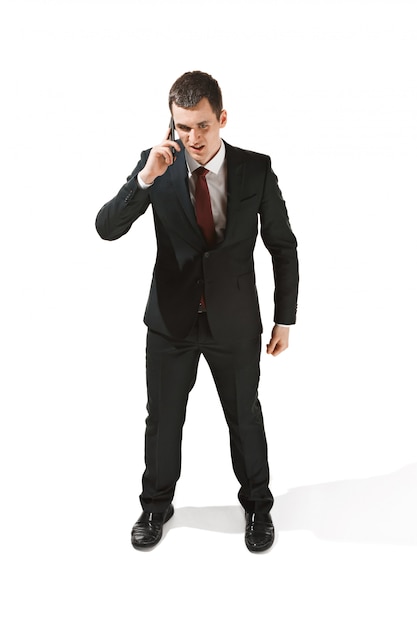 Retrato de un hombre de negocios con cara muy seria y hablando por teléfono