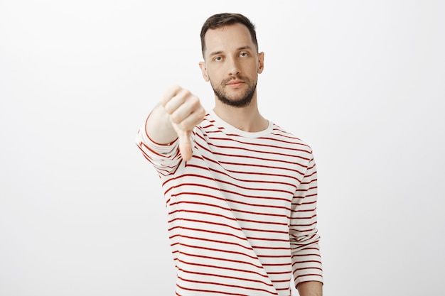 Retrato de hombre de negocios estricto indiferente e indiferente, mostrando aversión y actitud descuidada hacia las ideas de los empleados