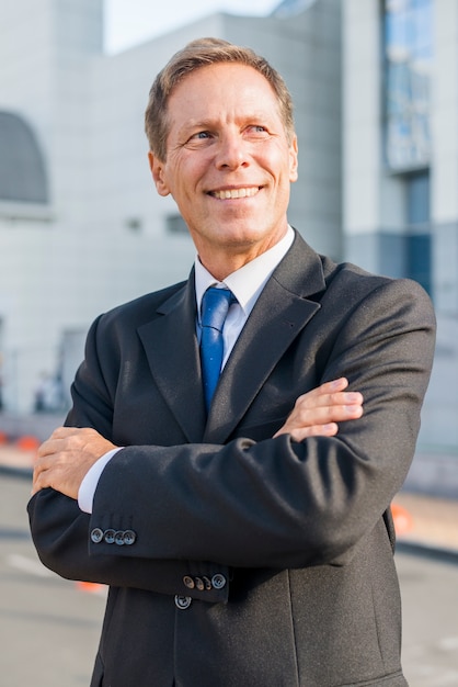 Retrato de un hombre de negocios feliz con los brazos cruzados