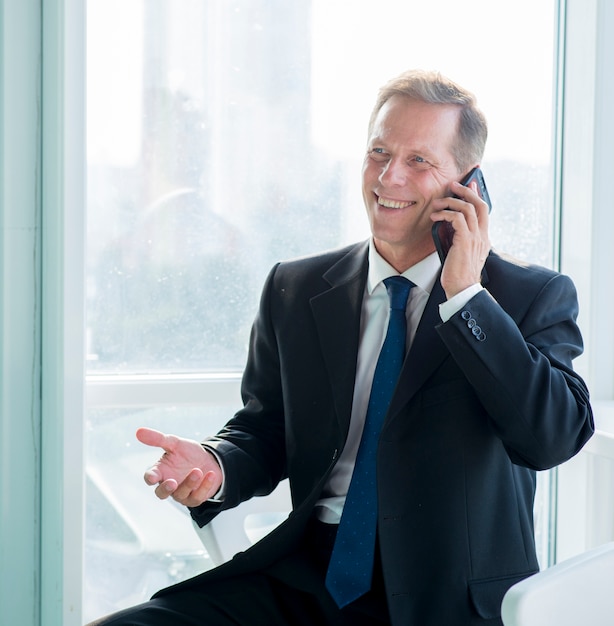 Retrato de un hombre de negocios feliz hablando por teléfono móvil