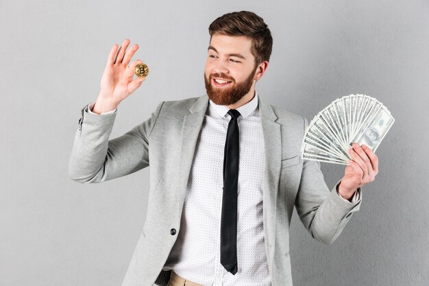 Retrato de un hombre de negocios feliz mostrando bitcoin