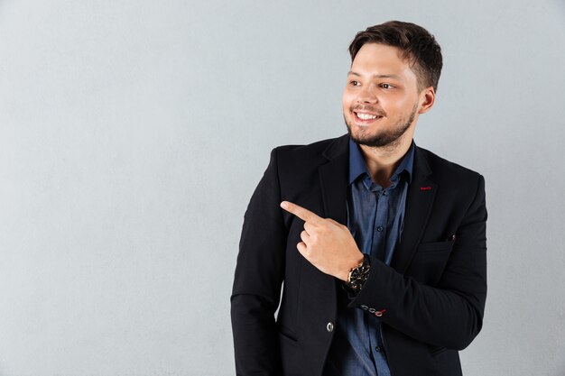 Retrato de un hombre de negocios feliz señalando con el dedo