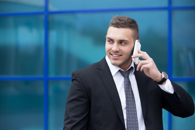 Retrato de hombre de negocios feliz en smartphone. Copiar espacio