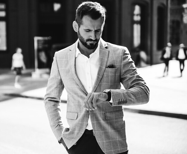 Retrato de hombre de negocios guapo modelo vestido con elegante traje azul. Hombre posando en el fondo de la calle. Metrosexual