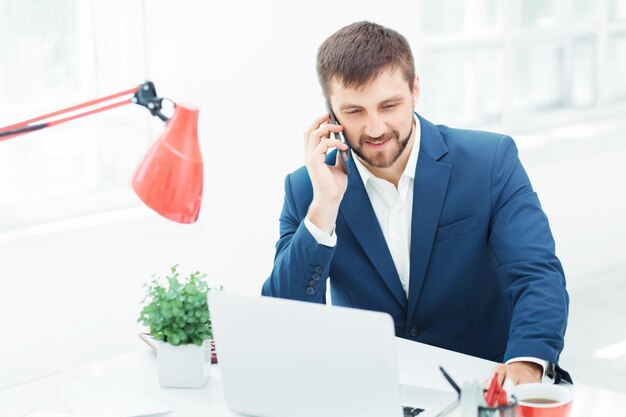 Retrato de hombre de negocios hablando por teléfono en la oficina