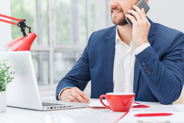 Retrato de hombre de negocios hablando por teléfono en la oficina