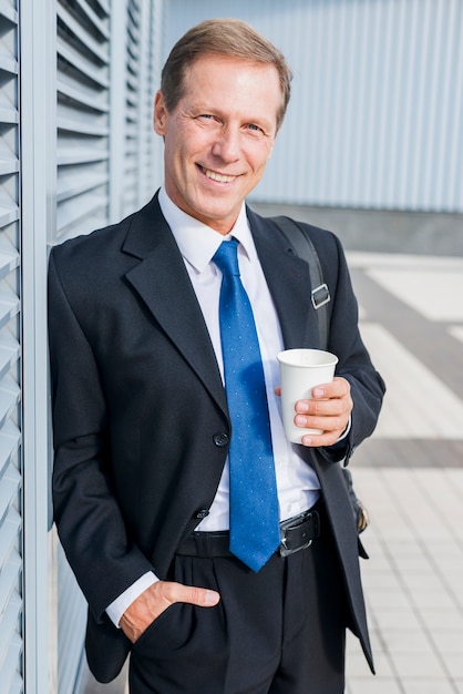 Retrato de un hombre de negocios maduro feliz con la taza de café