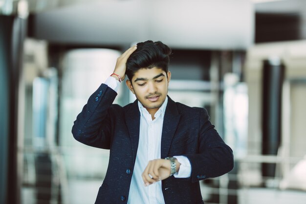 Retrato de un hombre de negocios mirando el reloj en la oficina