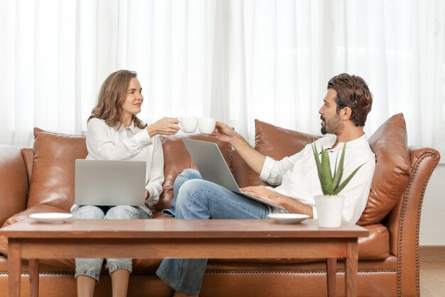 Retrato de hombre de negocios y mujer de negocios usando la computadora portátil en la oficina en casa