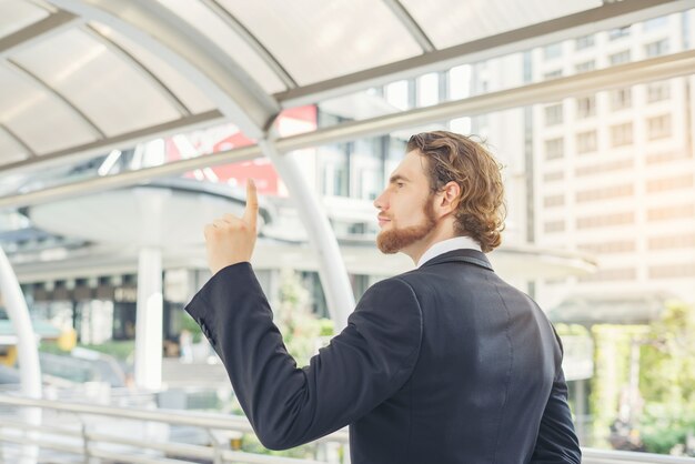 Retrato de hombre de negocios de pie contra el edificio al aire libre.