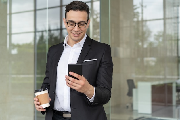 Retrato de hombre de negocios sonriente con mensaje de lectura de café