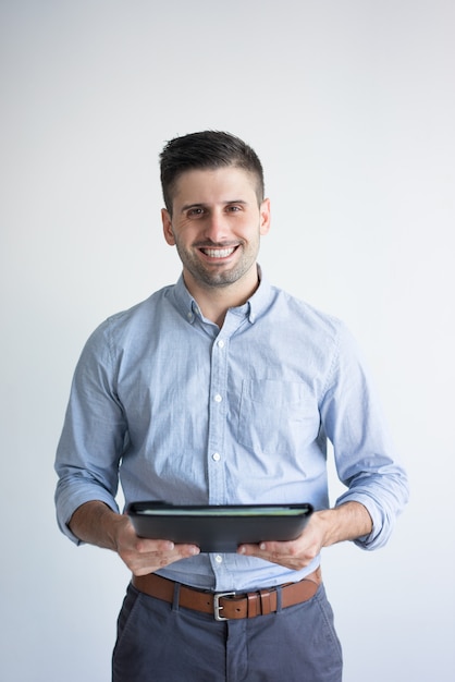 Retrato del hombre de negocios sonriente que sostiene la carpeta con los documentos.