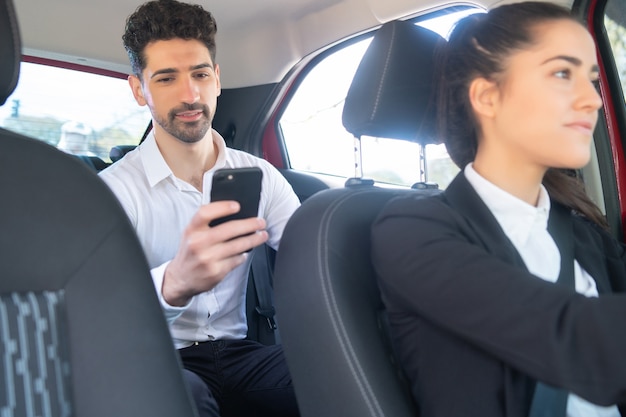 Retrato, de, hombre de negocios, utilizar, el suyo, teléfono móvil, en, camino al trabajo, en, un, taxi