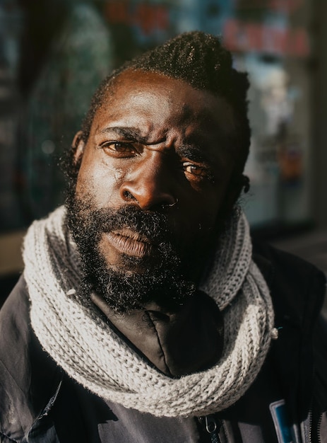 Foto gratuita retrato de un hombre negro en una calle con una expresión ceñuda