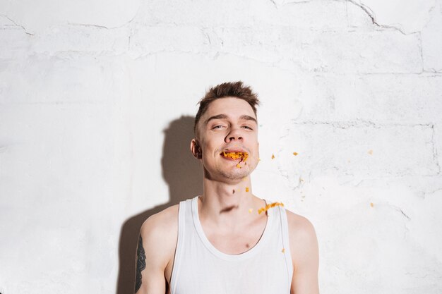 Retrato de hombre con papas fritas en la boca