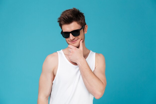 Retrato de un hombre pensativo sonriente en gafas de sol