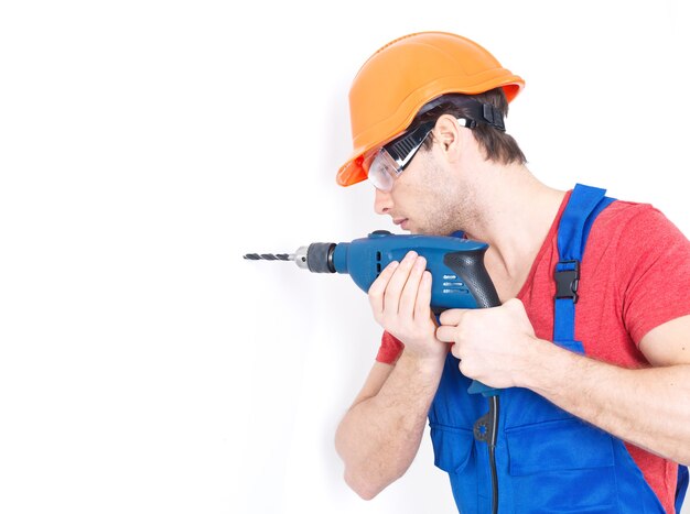 Retrato de un hombre perforando un agujero en la pared.