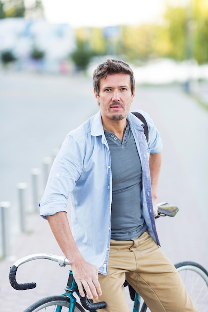 Retrato de hombre posando con su bicicleta