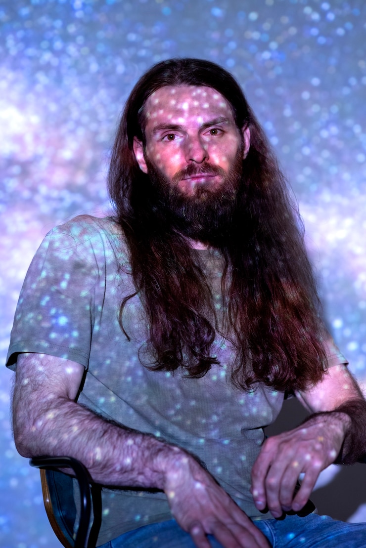 Foto gratuito retrato de hombre posando con textura de proyección del universo