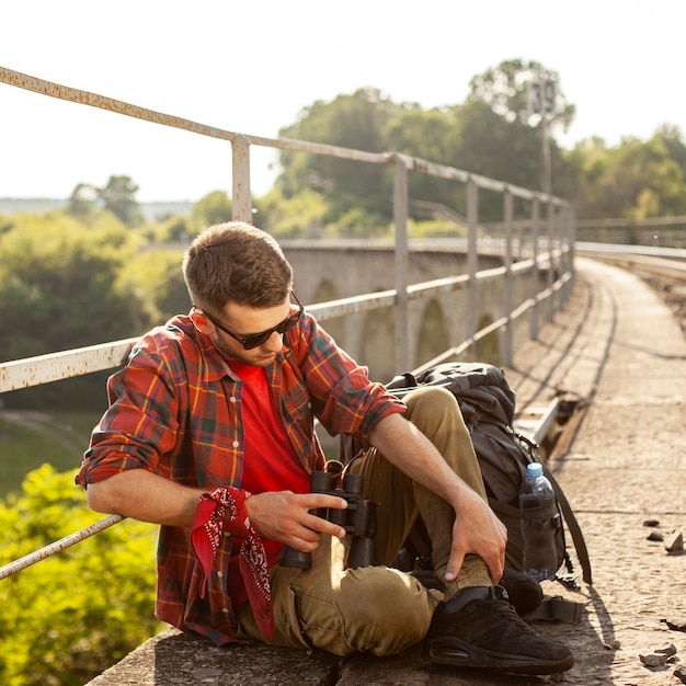 Foto gratuita retrato hombre en puente con descanso binocular