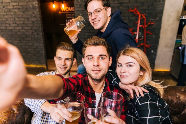 Retrato de un hombre que toma selfie en el teléfono móvil con su amigo