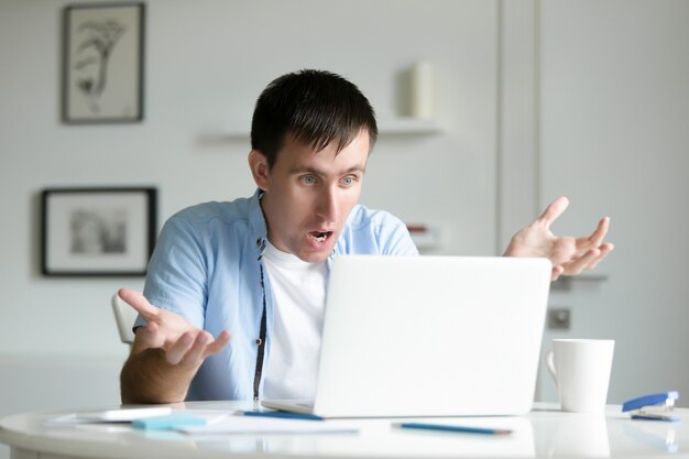 Retrato de un hombre que trabaja en el escritorio con la computadora portátil